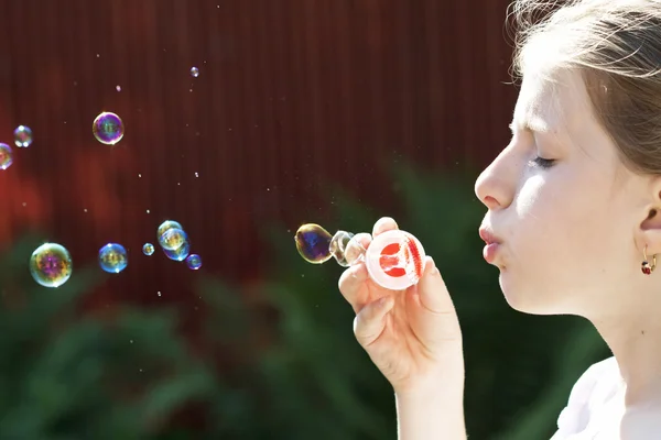 Young girl blowing soap bubbles — Stock Photo, Image