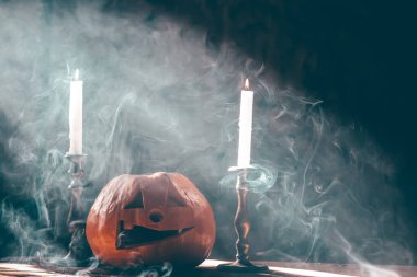 Jack O 'Lanternler dumanlı fantezi gecesinde mumlarla parlıyorlar. Cadılar Bayramı geçmişi