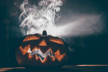 Jack O 'Lantern dumanlı fantezi gecesinde parlıyor. Cadılar Bayramı geçmişi