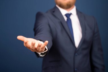  Takım elbiseli bir iş adamı avucunun içinde hayali bir şey tutuyor. İş ve reklam kavramı