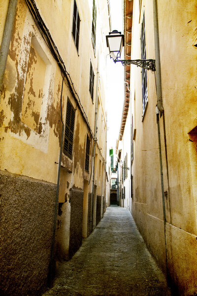 Vintage photo of narrow street in old city of Palma de Mallorca, Spain
