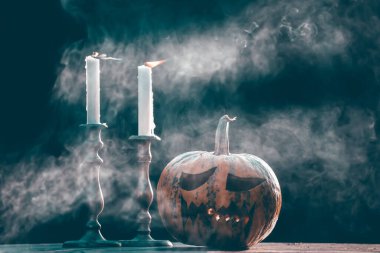 Jack O 'Lanternler dumanlı fantezi gecesinde mumlarla parlıyorlar. Cadılar Bayramı geçmişi