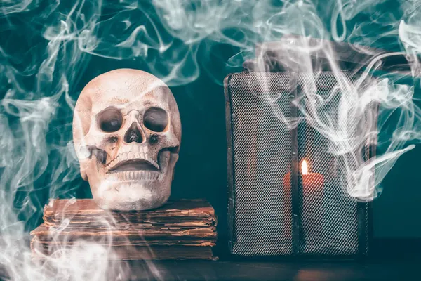 stock image Vintage skull on antique book with candle. Halloween concept.
