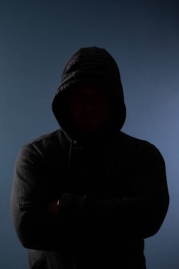 Gölgelerde saklanan korkunç bir adam. Kapüşonlu yüzü ve kimliği saklı. Korku, gizem, tehlike, suç, takipçi kavramı