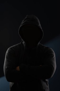 Gölgelerde saklanan korkunç bir adam. Kapüşonlu yüzü ve kimliği saklı. Korku, gizem, tehlike, suç, takipçi kavramı