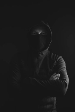 Gölgelerde saklanan korkunç bir adam. Kapüşonlu yüzü ve kimliği saklı. Korku, gizem, tehlike, suç, takipçi kavramı