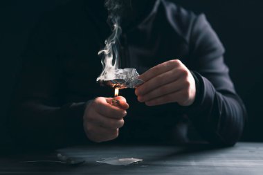 Bağımlı / bağımlı adam uyuşturucu hazırlıyor. Suç ve uyuşturucu bağımlılığı kavramı.