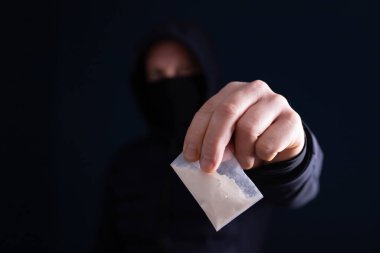 Bir doz kokain ya da eroin tutan bir bağımlı. Uyuşturucu satıcısı, uyuşturucu ticareti, suç, bağımlılık ve satış kavramı.