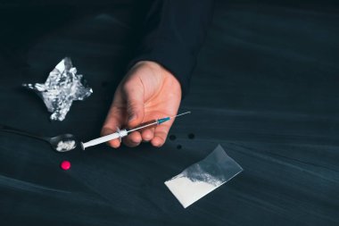 Uyuşturucu bağımlısı bir doz daha ilaç alıyor. Bağımlılık kavramı, anti-ilaç. Uyuşturucu Bağımlılığına Karşı Uluslararası Gün.