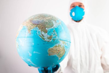 Dünya salgını tehlike kavramı. Dünya gezegenini koruyan tıbbi maskeli ve eldivenli erkek doktor..