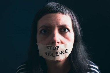 Kadın şiddeti ve istismar konsepti. Kadınlara ve insan kaçakçılığına karşı aile içi şiddeti durdurun. Ağzı bantlı kadın ve şiddet mesajlarını durdurun.