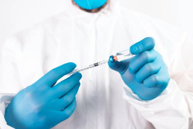 COVID-19 koronavirüs aşısı. Aşı konsepti. Doktorun elinde mavi eldivenler ilaç aşısı şişesi ve şırınga var.. 