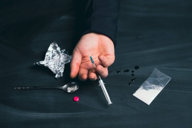 Uyuşturucu bağımlısı bir doz daha ilaç alıyor. Bağımlılık kavramı, anti-ilaç. Uyuşturucu Bağımlılığına Karşı Uluslararası Gün.