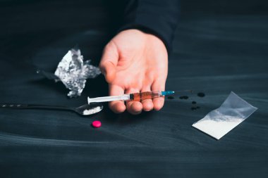 Uyuşturucu bağımlısı bir doz daha ilaç alıyor. Bağımlılık kavramı, anti-ilaç. Uyuşturucu Bağımlılığına Karşı Uluslararası Gün.