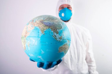 Dünya salgını tehlike kavramı. Dünya gezegenini koruyan tıbbi maskeli ve eldivenli erkek doktor..