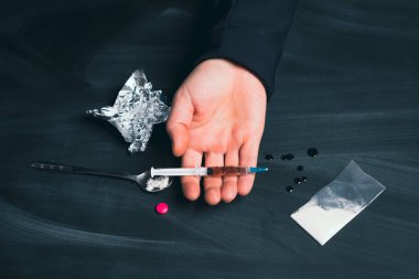 Uyuşturucu bağımlısı bir doz daha ilaç alıyor. Bağımlılık kavramı, anti-ilaç. Uyuşturucu Bağımlılığına Karşı Uluslararası Gün.