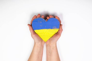 Ukrayna 'nın kalp şeklinde bayrağı kadınların elinde. Ukrayna vatandaşlarıyla dayanışma kavramı.