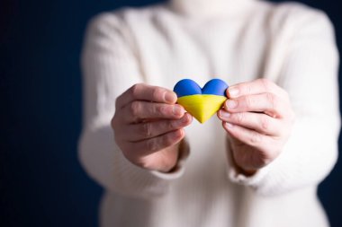 Ukrayna 'nın kalp şeklinde bayrağı kadınların elinde. Ukrayna vatandaşlarıyla dayanışma kavramı.