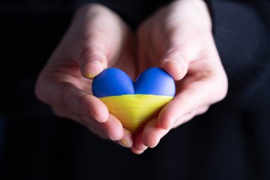 Ukrayna 'nın kalp şeklinde bayrağı kadınların elinde. Ukrayna vatandaşlarıyla dayanışma kavramı.