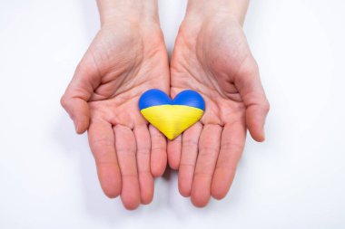 Ukrayna 'nın kalp şeklinde bayrağı kadınların elinde. Ukrayna vatandaşlarıyla dayanışma kavramı.