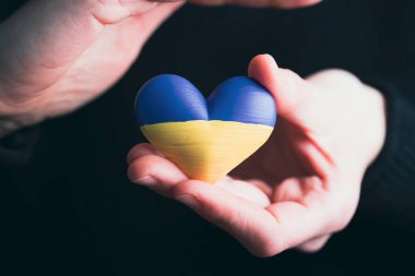 Ukrayna 'nın kalp şeklinde bayrağı kadınların elinde. Ukrayna vatandaşlarıyla dayanışma kavramı.