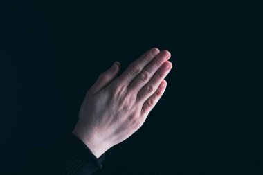Karanlık arka planda din ve Tanrı'ya inanç ile dua eller. Umudun, sevginin ve bağlılığın gücü.