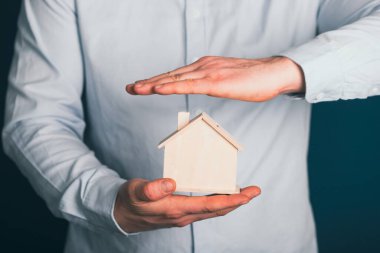 Emlakçı ev modelini koruyor. Emlak sigortası ve güvenlik kavramı.