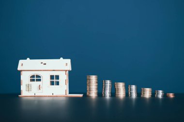 Gayrimenkul acentesinin elinde bozuk para yığınının yanında anahtarı tutuyor. Emlakçı, ipotek, evin, ev kredisi konsepti. Boşluğu kopyala