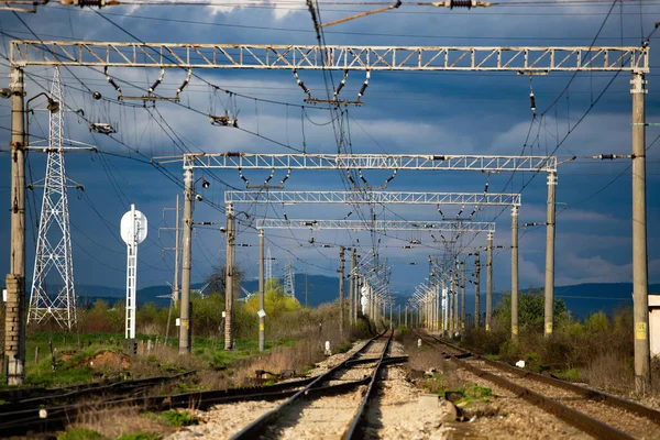 Demiryolu ile endüstriyel manzara, dramatik bulutlarla mavi gökyüzü. Demiryolu kavşağı. Ağır sanayi.