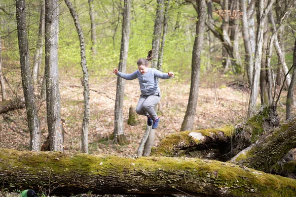 Κοριτσάκι Διασκεδάζει Πηδάει Στο Δάσος Έννοια Της Υπαίθριας Αναψυχής Και — Φωτογραφία Αρχείου