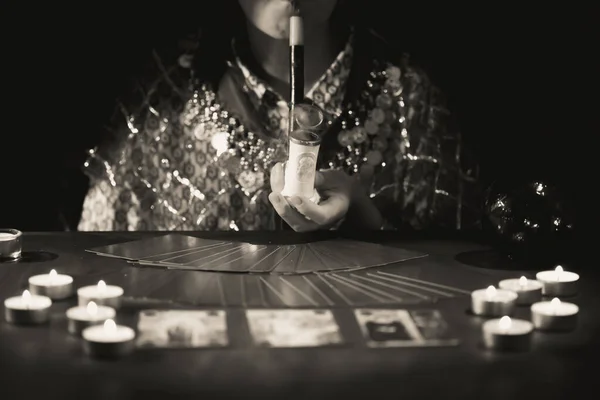 燃えるろうそくの近くのテーブルの上にタロットカードを持つ占い師 水晶球でテーブルの上に広がるタロットカード — ストック写真