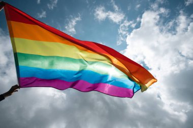 Parlak gökkuşağı Lgbt bayrağı mavi gökyüzüne karşı çırpınıyor. Aynı cinsiyetli çiftler için LGBT topluluğu, mutluluk, özgürlük ve aşk kavramı.