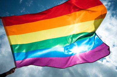 Parlak gökkuşağı Lgbt bayrağı mavi gökyüzüne karşı çırpınıyor. Aynı cinsiyetli çiftler için LGBT topluluğu, mutluluk, özgürlük ve aşk kavramı.
