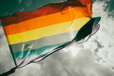 Parlak gökkuşağı Lgbt bayrağı mavi gökyüzüne karşı çırpınıyor. Aynı cinsiyetli çiftler için LGBT topluluğu, mutluluk, özgürlük ve aşk kavramı.