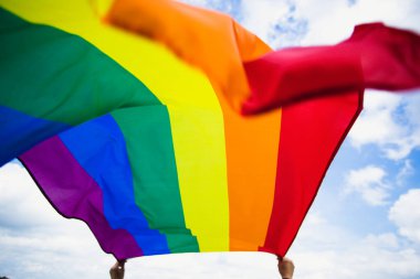 Parlak gökkuşağı Lgbt bayrağı mavi gökyüzüne karşı çırpınıyor. Aynı cinsiyetli çiftler için LGBT topluluğu, mutluluk, özgürlük ve aşk kavramı.