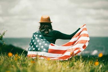 Amerikan bayrağı tutan genç bir kadın. Bağımsızlık Günü ya da Amerika 'da seyahat. 