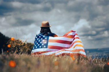 Amerikan bayrağı tutan genç bir kadın. Bağımsızlık Günü ya da Amerika 'da seyahat. 