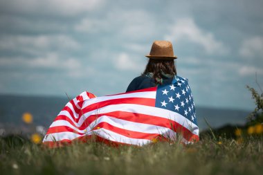 Amerikan bayrağı tutan genç bir kadın. Bağımsızlık Günü ya da Amerika 'da seyahat. 