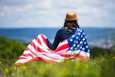 Amerikan bayrağı tutan genç bir kadın. Bağımsızlık Günü ya da Amerika 'da seyahat. 