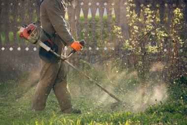 Çim biçme makinesiyle çimleri biçmek. Bahçe işleri konsepti.