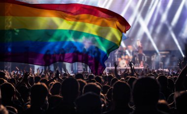 Onur topluluğunun elleri havada bir geçit töreni ve LGBT bayrağı - sevgi ve hoşgörünün sembolü