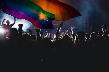 Onur topluluğunun elleri havada bir geçit töreni ve LGBT bayrağı - sevgi ve hoşgörünün sembolü