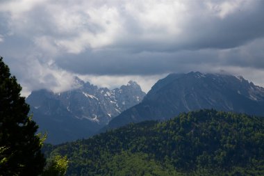 İlkbaharda bulutlarda zirveleri olan Alpler, Avusturya