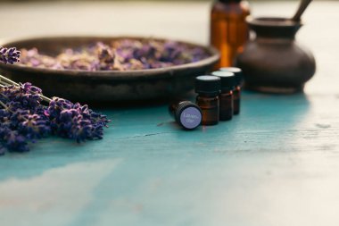 Bir şişe lavanta yağı ve ahşap kırsal masada taze lavanta çiçekleri. Aromaterapi, spa, masaj konsepti.