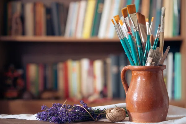 Still Life Paint Brushes Clay Jug Old Books Background — Photo