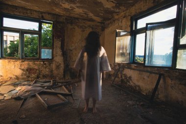 Ghost in abandoned, haunted house. Horror scene of scary spirit of a woman, halloween concept.