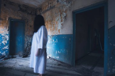 Ghost in abandoned, haunted house. Horror scene of scary spirit of a woman, halloween concept.