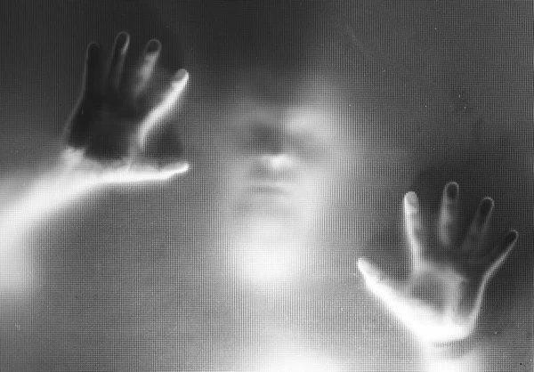 Horror ghost man behind the matte glass. Halloween festival concept.
