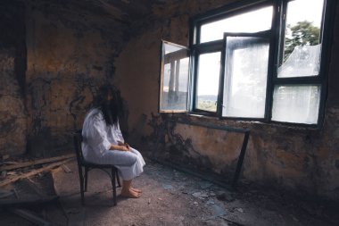 Ghost in abandoned, haunted house. Horror scene of scary spirit of a woman, halloween concept.