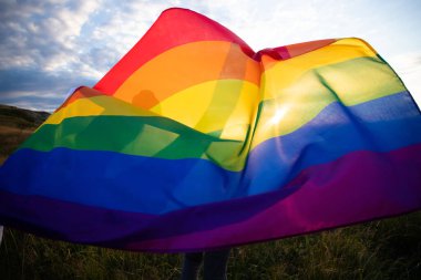 Woman holding a Gay Rainbow Flag.Happiness, freedom and love concept for same sex couples